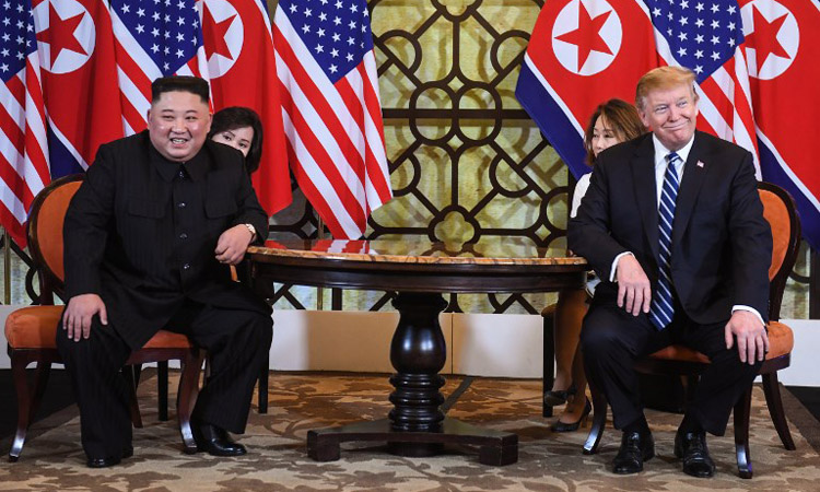 US President Donald Trump (R) and North Korea's leader Kim Jong Un smile during a meeting at the second US-North Korea summit at the Sofitel Legend .